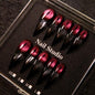 Wine red cat-eye pointed press-on nails, elegant long pointed false nails with a glossy chrome gold finish, creating a seductive, high-end nail design.