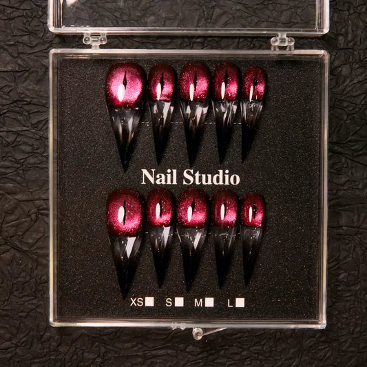 Wine red cat-eye pointed press-on nails, elegant long pointed false nails with a glossy chrome gold finish, creating a seductive, high-end nail design.