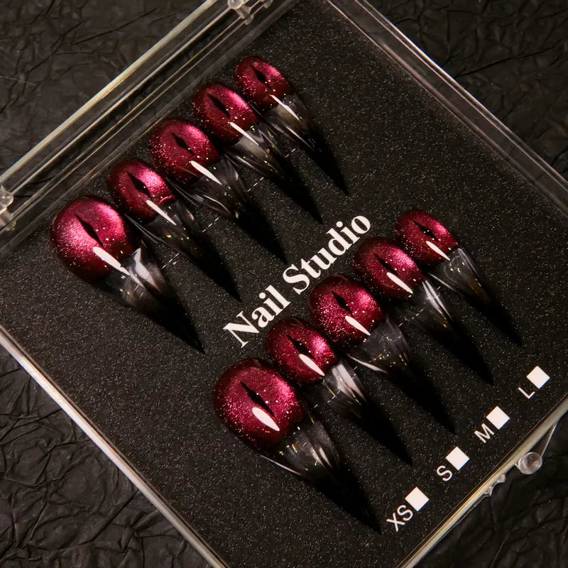 Wine red cat-eye pointed press-on nails, elegant long pointed false nails with a glossy chrome gold finish, creating a seductive, high-end nail design.