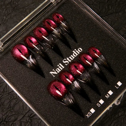 Wine red cat-eye pointed press-on nails, elegant long pointed false nails with a glossy chrome gold finish, creating a seductive, high-end nail design.