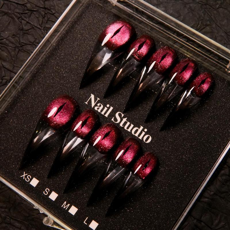 Wine red cat-eye pointed press-on nails, elegant long pointed false nails with a glossy chrome gold finish, creating a seductive, high-end nail design.