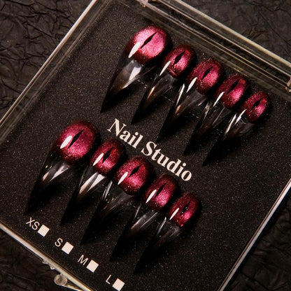 Wine red cat-eye pointed press-on nails, elegant long pointed false nails with a glossy chrome gold finish, creating a seductive, high-end nail design.