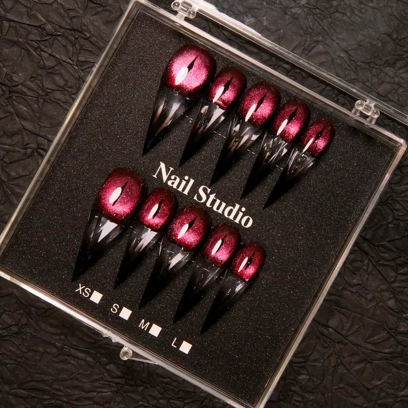 Wine red cat-eye pointed press-on nails, elegant long pointed false nails with a glossy chrome gold finish, creating a seductive, high-end nail design.