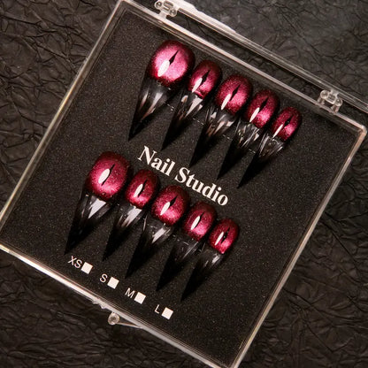 Wine red cat-eye pointed press-on nails, elegant long pointed false nails with a glossy chrome gold finish, creating a seductive, high-end nail design.
